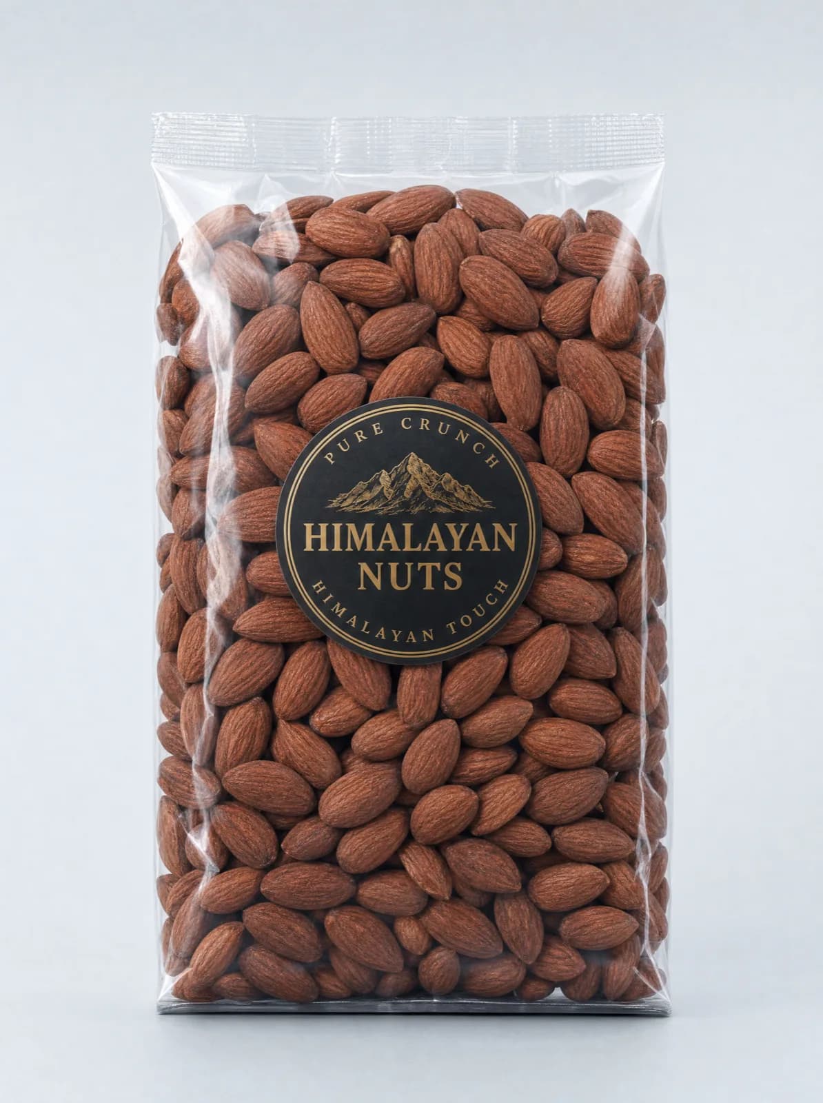 A sealed clear bag of whole almonds with a round black and gold Himalayan Nuts seal