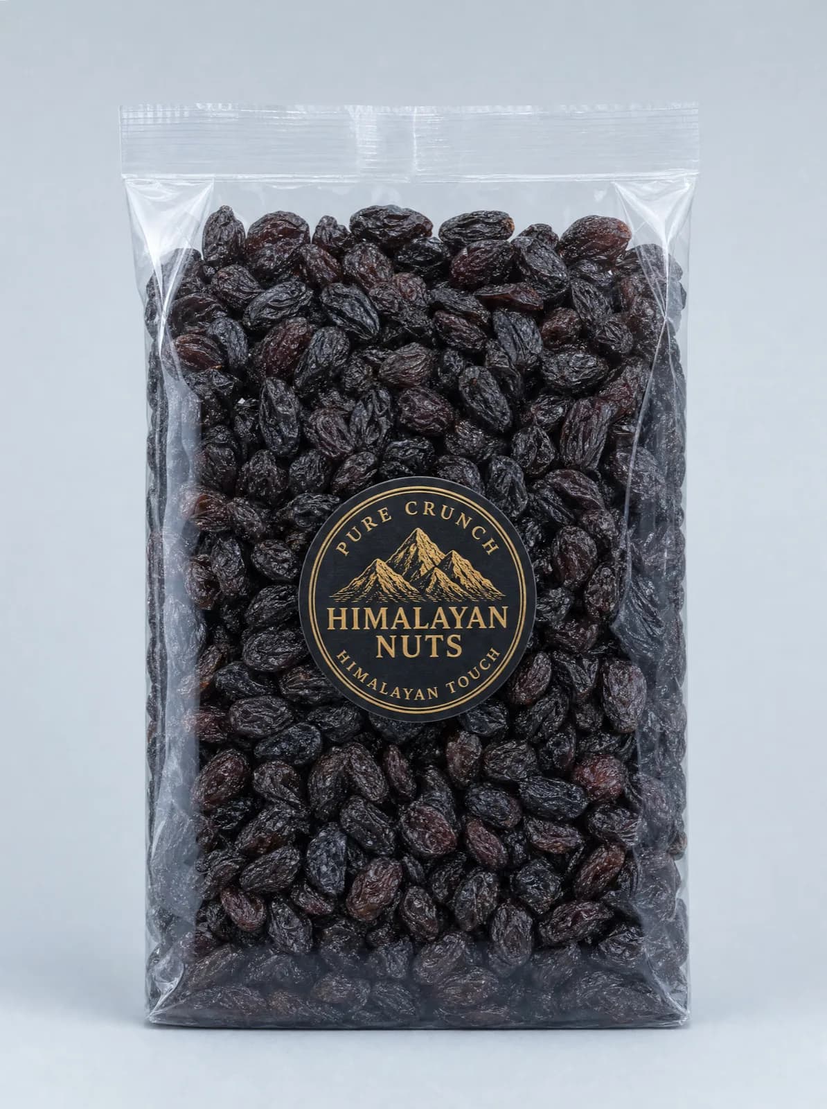 A sealed clear bag of dark seedless raisins with a round black and gold Himalayan Nuts seal